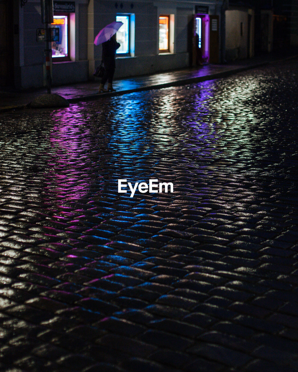 REFLECTION OF WOMAN WALKING ON ILLUMINATED MIRROR