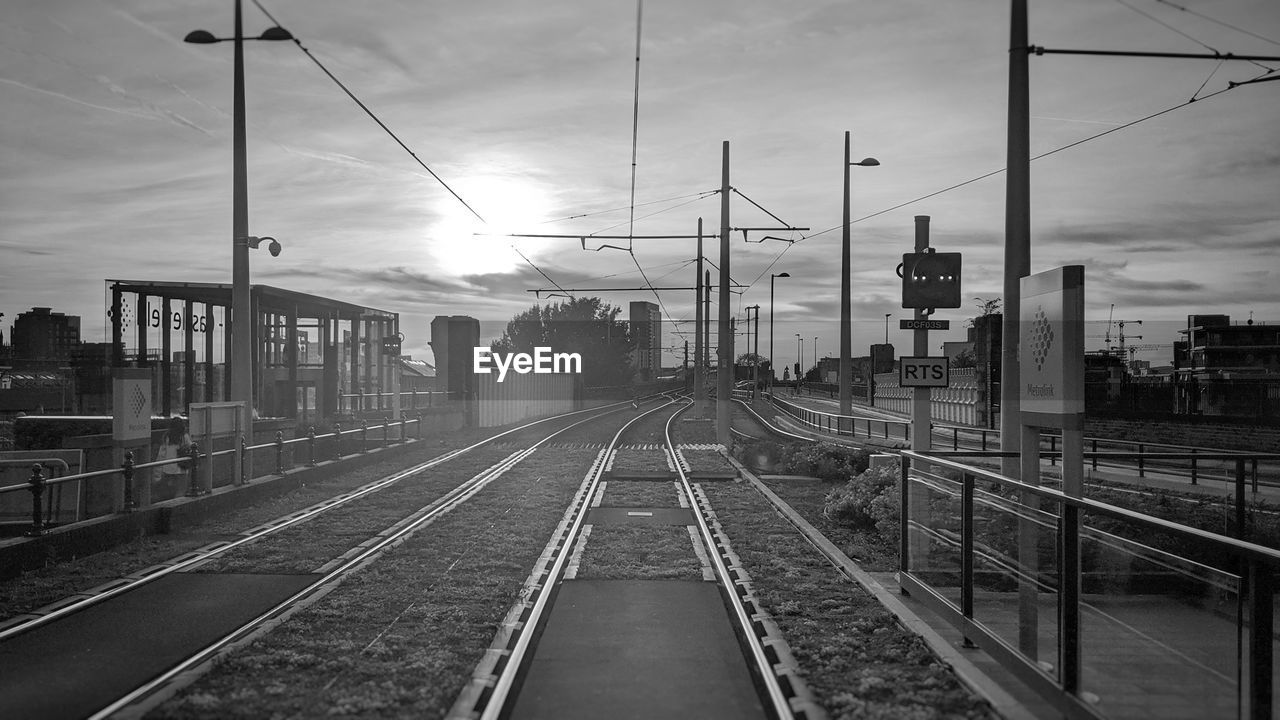 RAILROAD TRACKS AGAINST SKY DURING SUNSET