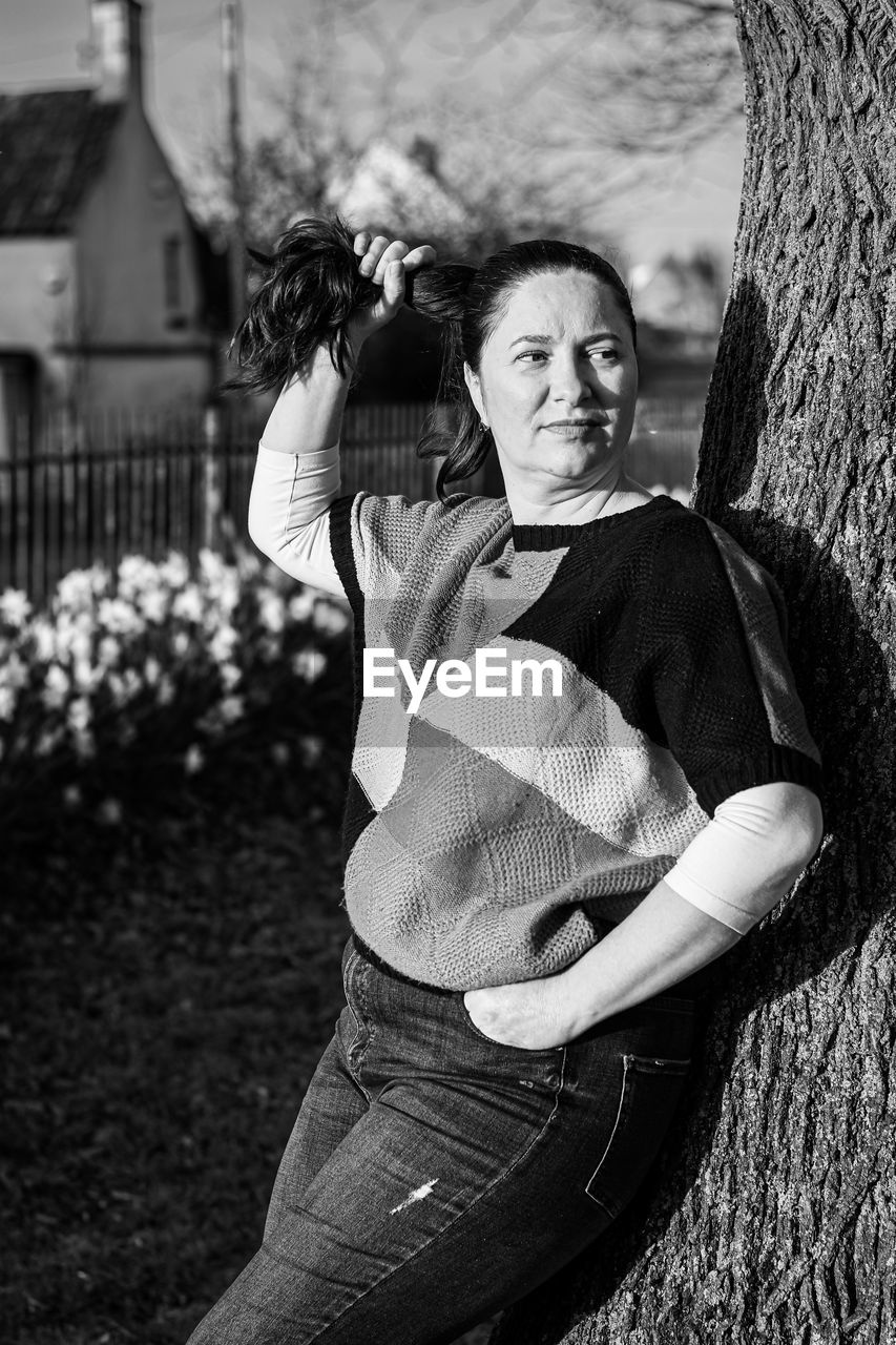 Portrait of woman against tree trunk