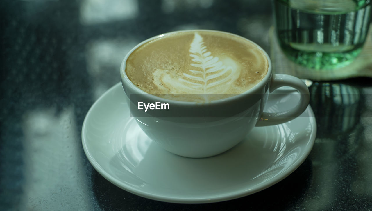 Hot coffee with latte art on dark table