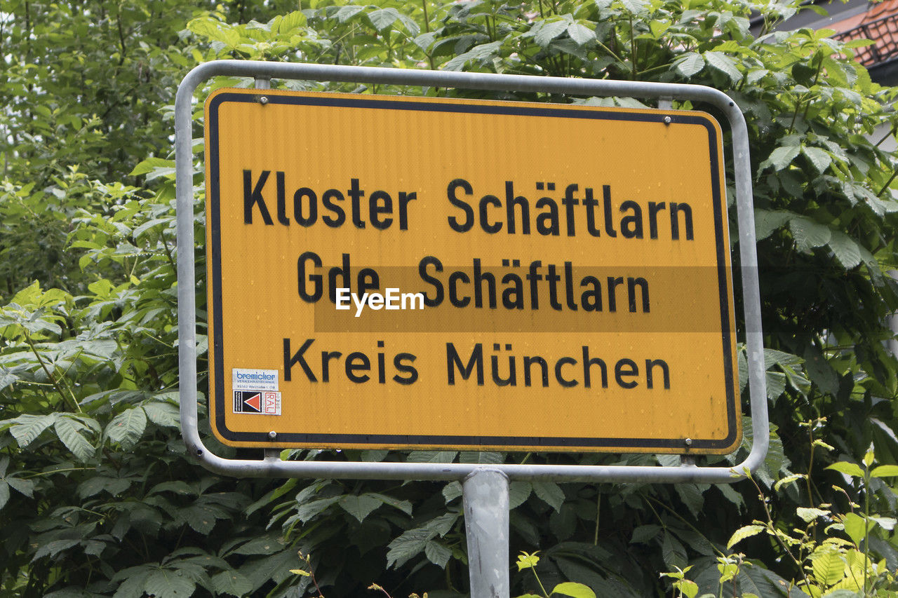 communication, sign, text, western script, plant, street sign, warning sign, signage, no people, day, nature, guidance, traffic sign, information sign, yellow, growth, outdoors, road sign, road, green, tree, leaf, close-up