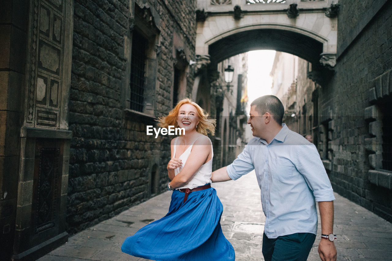 Cheerful couple dancing in alley