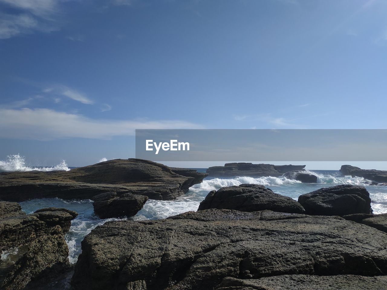 Scenic view of rocks on beach against sky