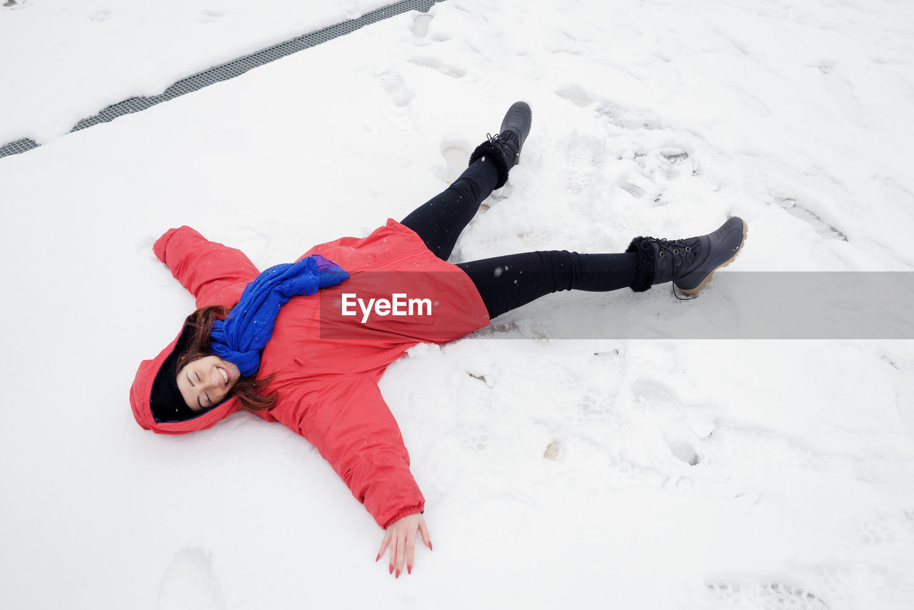 High angle view of woman making snow angel on land