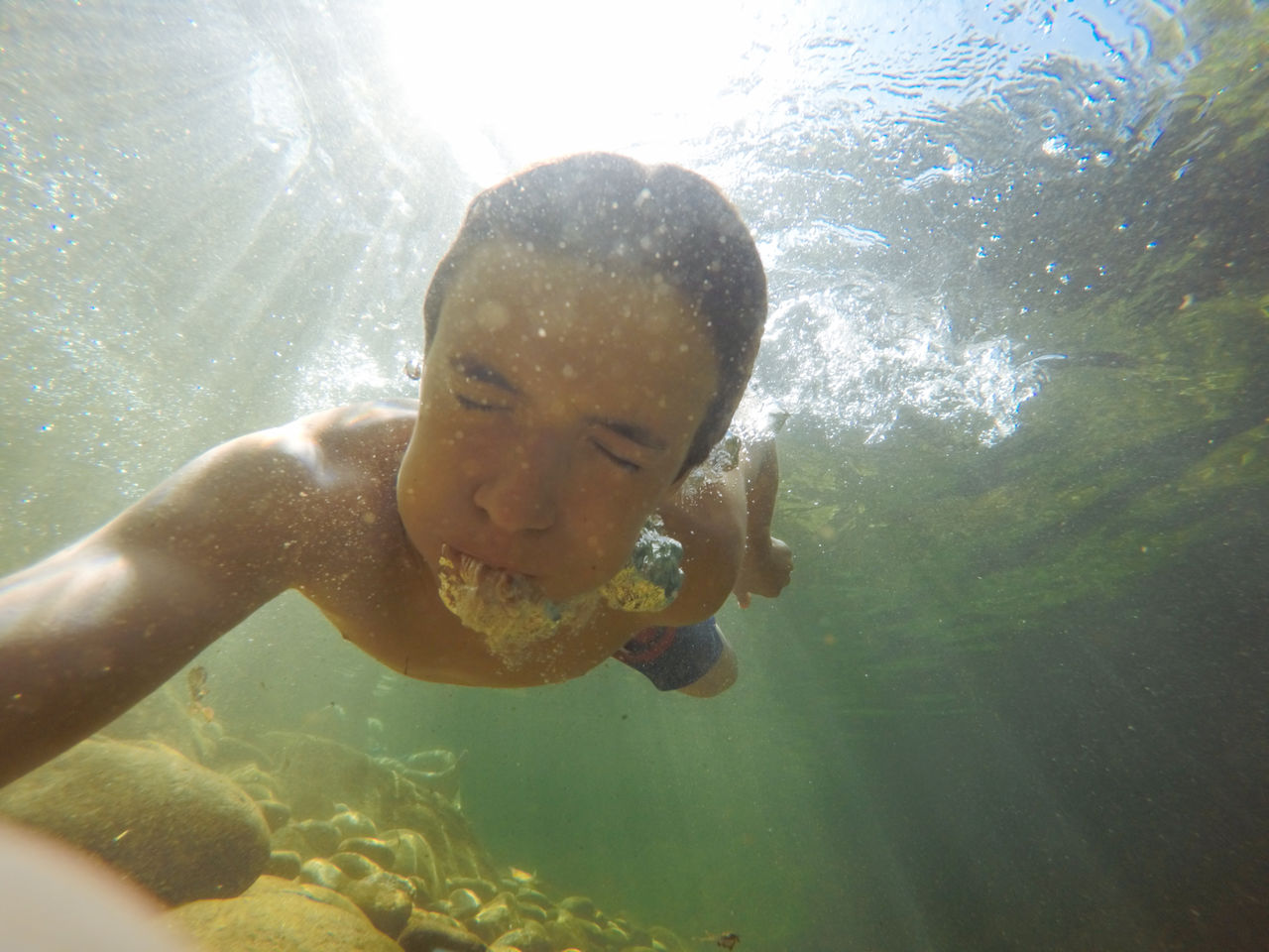 Teenage boy swimming underwater