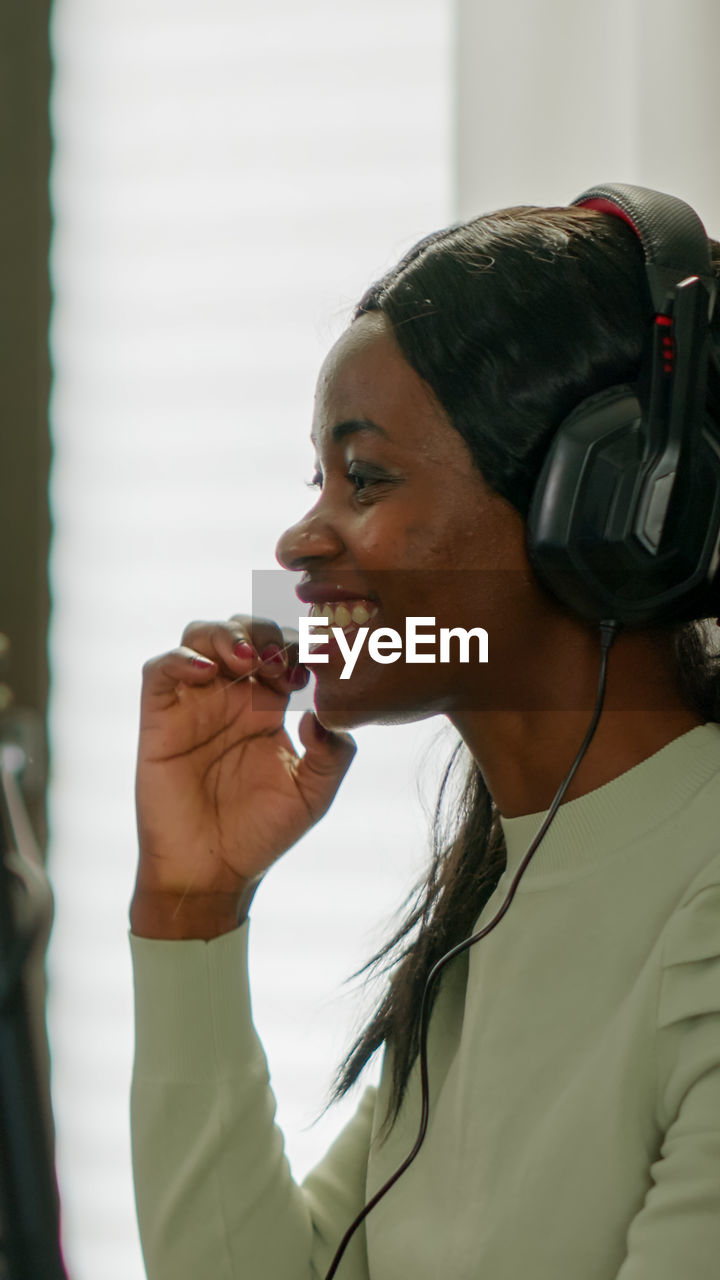 Side view of young woman wearing headphones