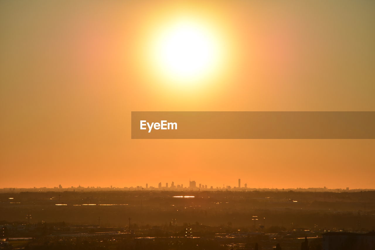 Cityscape against orange sky during sunset