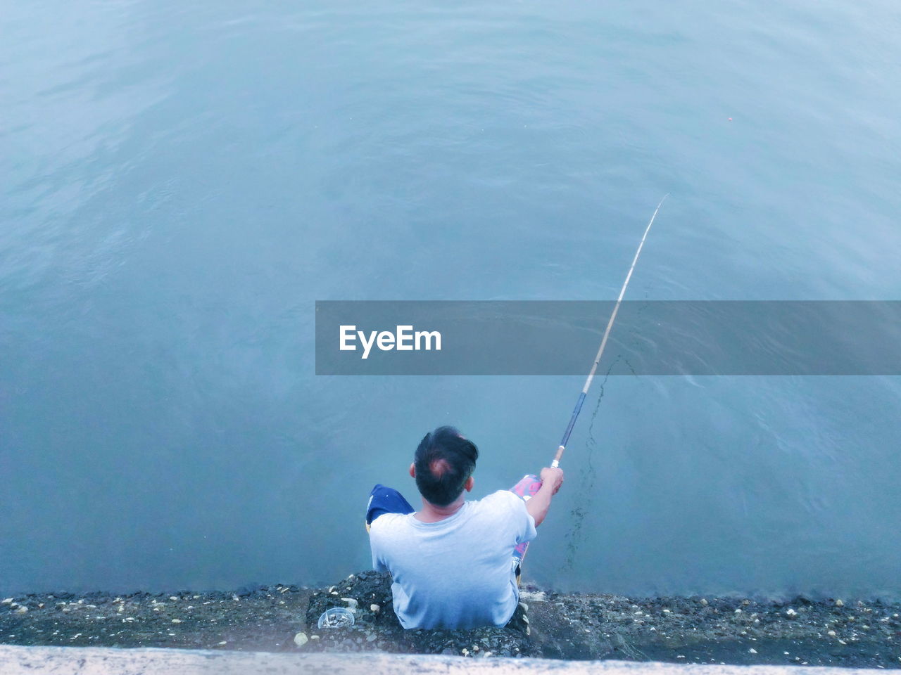 MAN FISHING IN SEA WATER