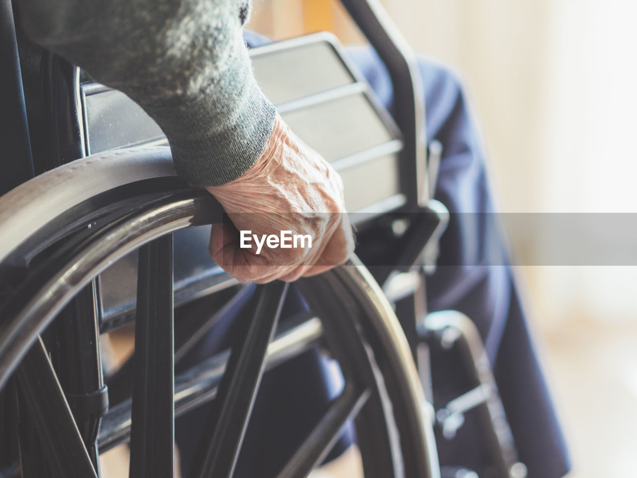 Midsection of senior man sitting on wheelchair