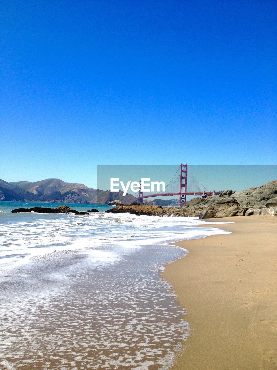 View of suspension bridge against clear blue sky