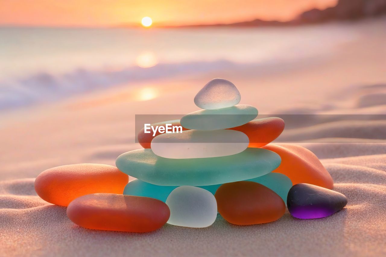 land, sunset, sand, beach, nature, sky, sea, multi colored, no people, water, orange color, sun, focus on foreground, holiday, tranquility, environment, outdoors, sunlight, beauty in nature, cloud, tranquil scene, close-up, zen-like