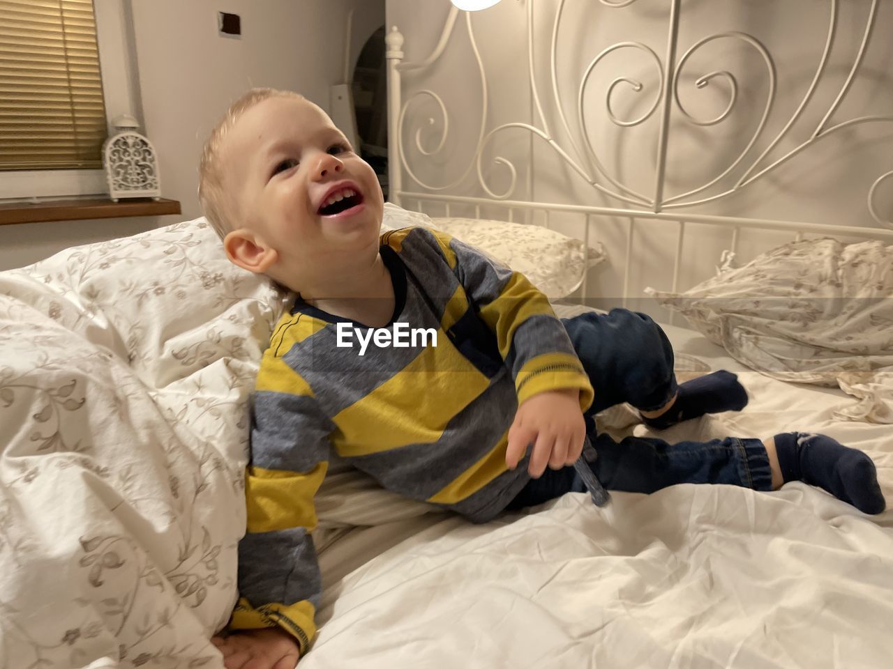 Portrait of cute girl playing on bed at home