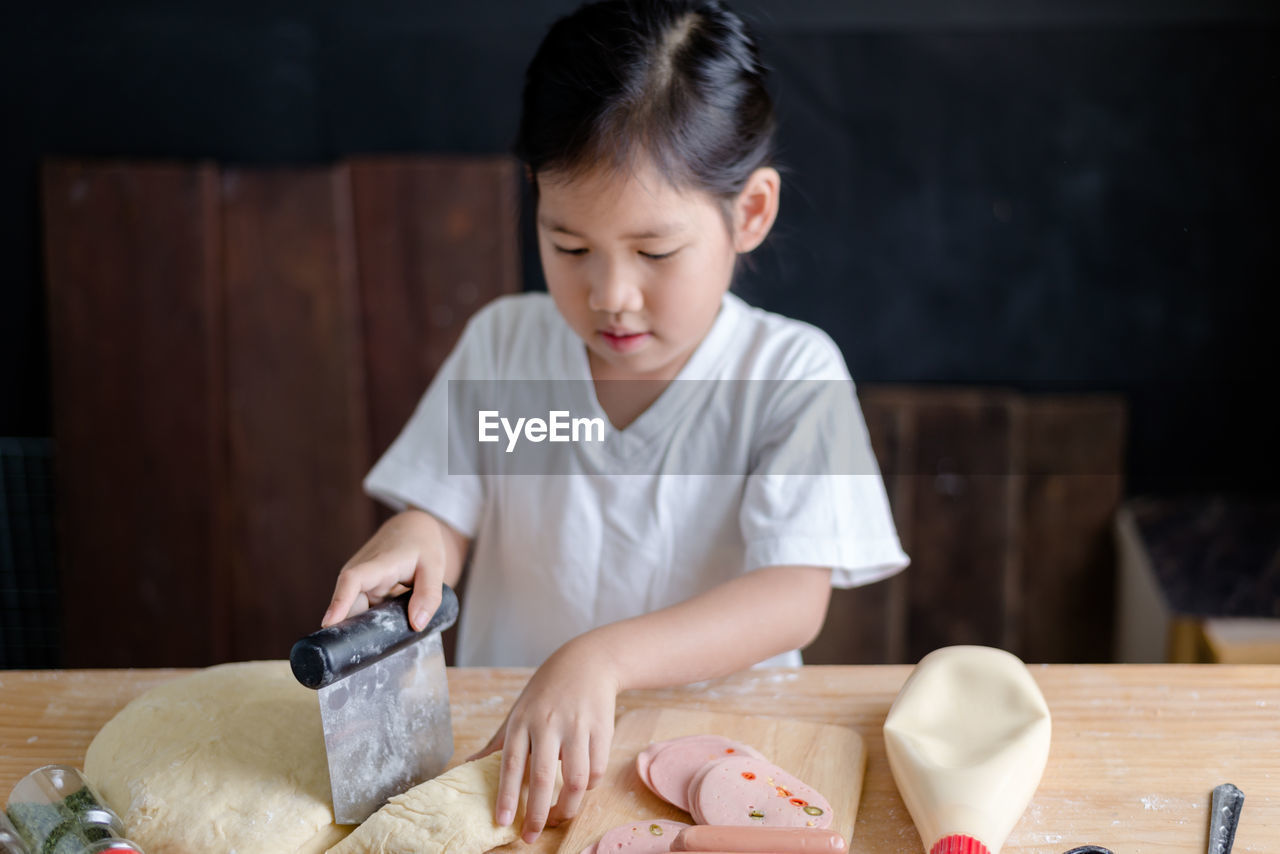 Close-up of girl preparing food on table