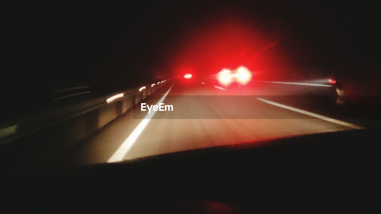 CLOSE-UP OF TRAFFIC ON ROAD AT NIGHT