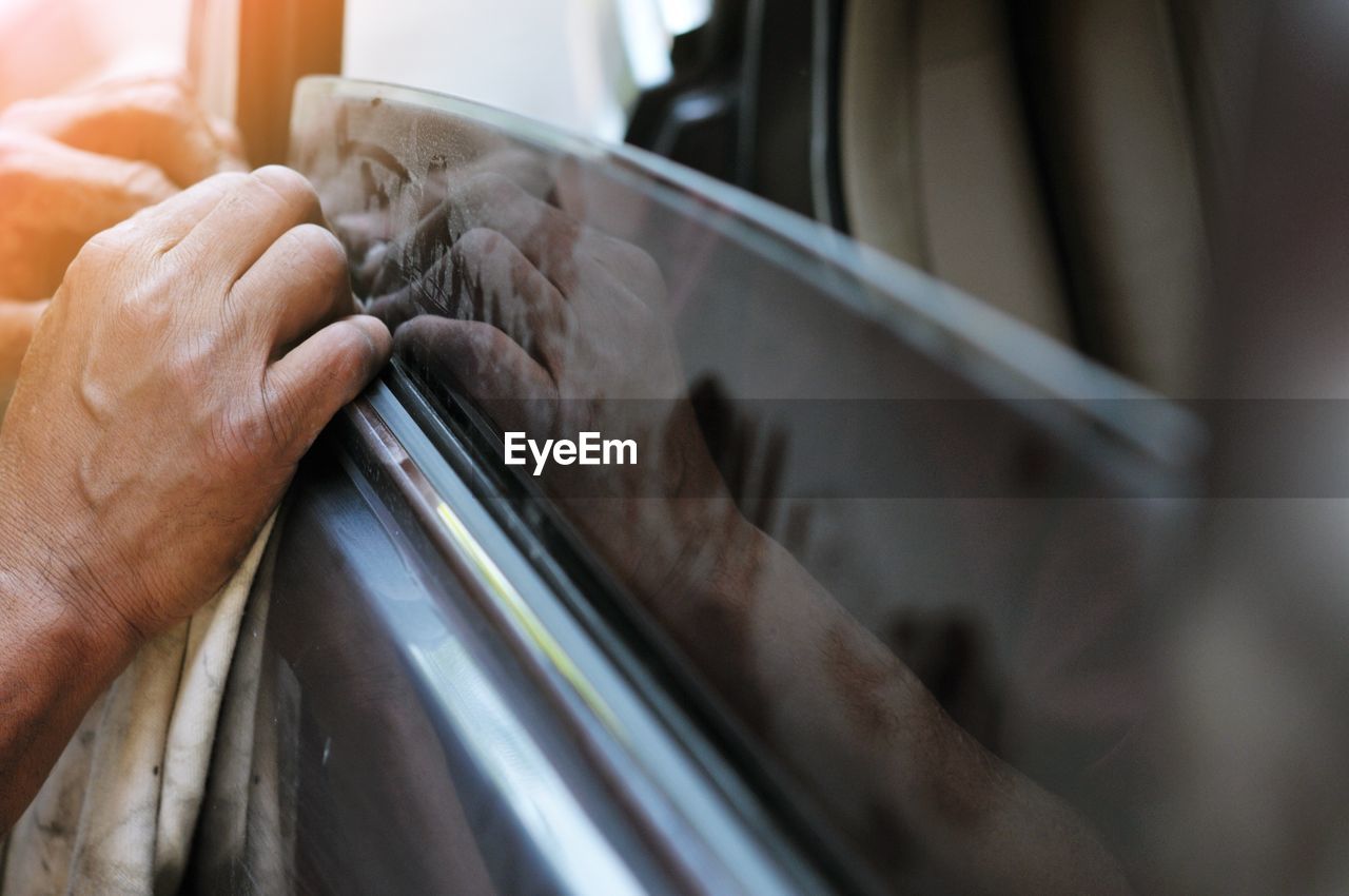 hand, close-up, wheel, one person, adult, indoors, occupation, selective focus, working, mode of transportation, motor vehicle, transportation, car, holding, men, tire, cleaning, skill, business, glass, windshield, limb
