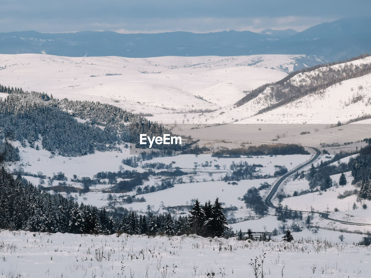 SNOW COVERED LANDSCAPE AGAINST SKY