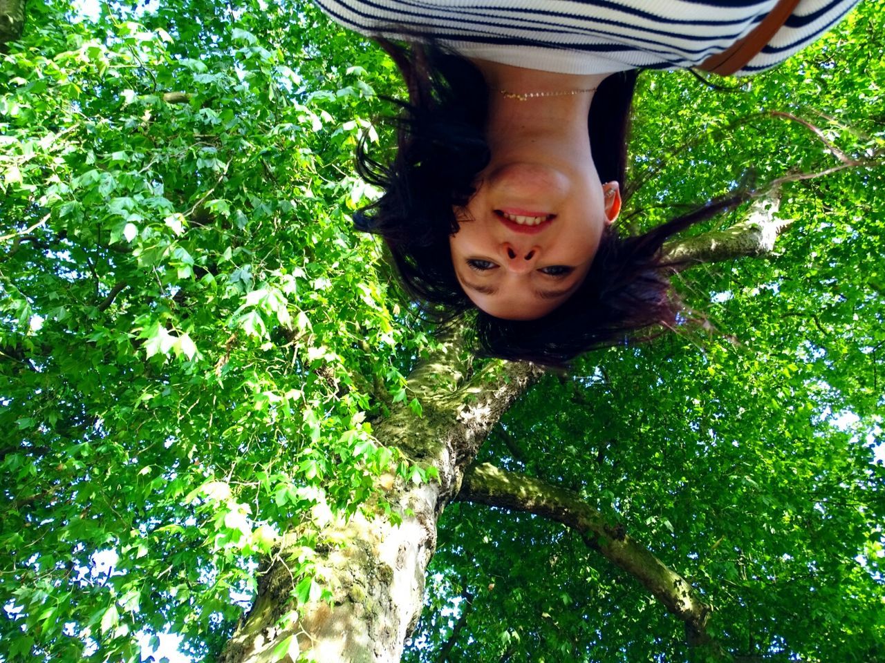 Portrait of smiling woman standing against tree