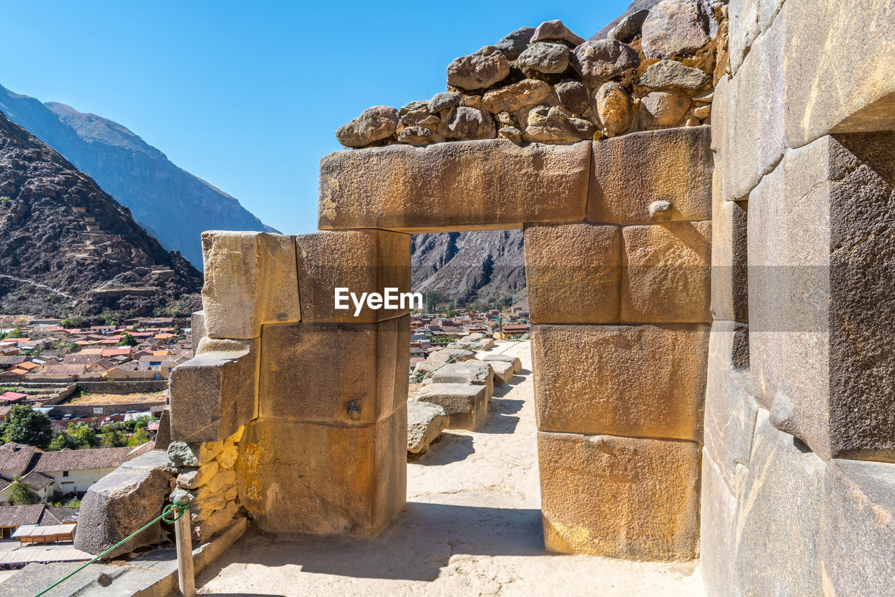 Stone doorway at ollantaytambo ruins, peru against blue sky 