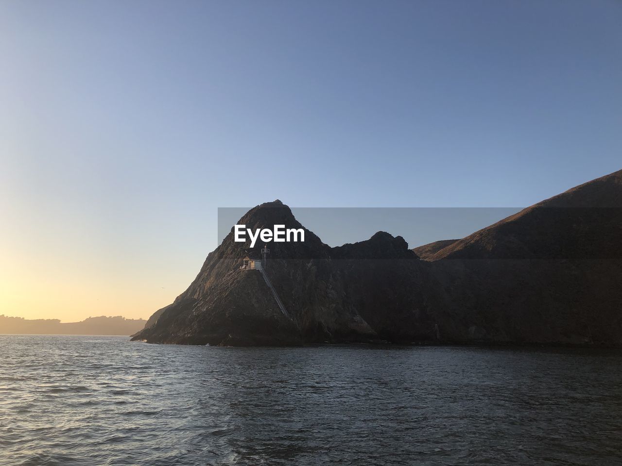 Scenic view of sea and mountains against clear sky