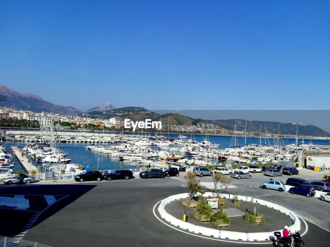 Boats moored on river by mountains against clear sky