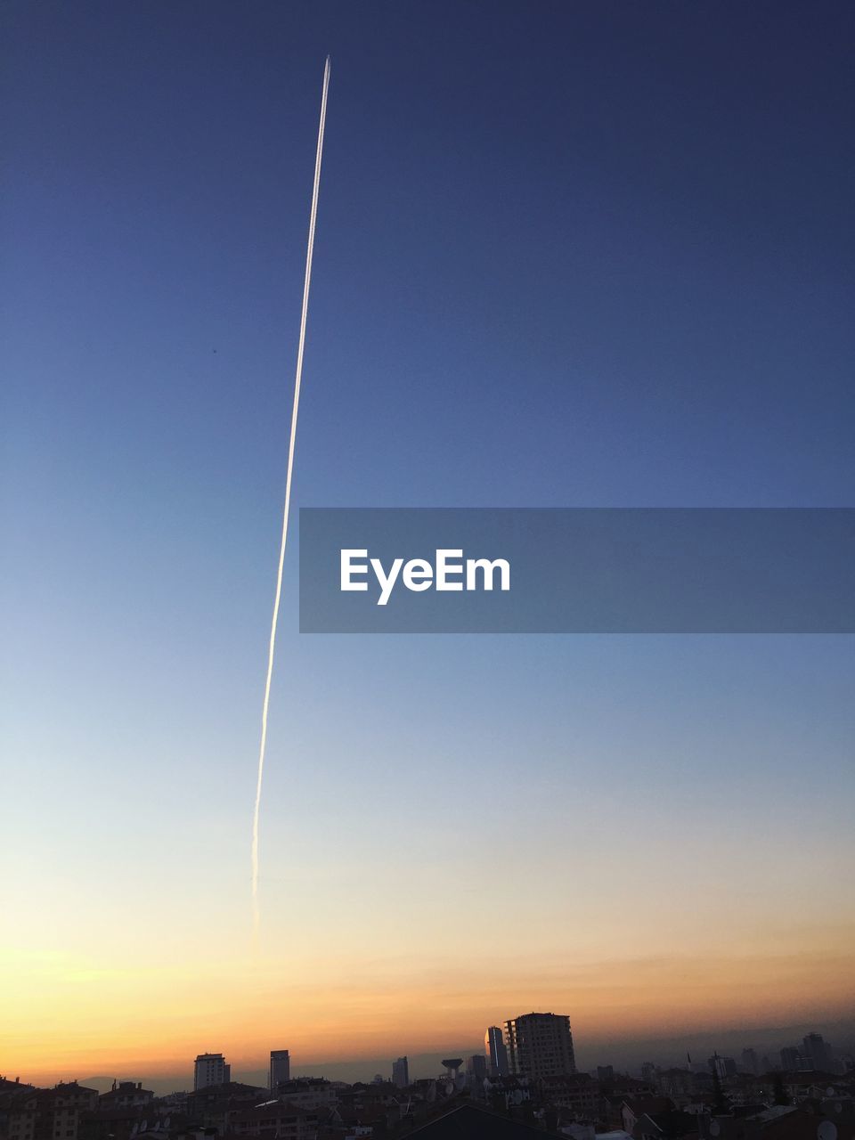 Scenic view of vapor trails in sky during sunset