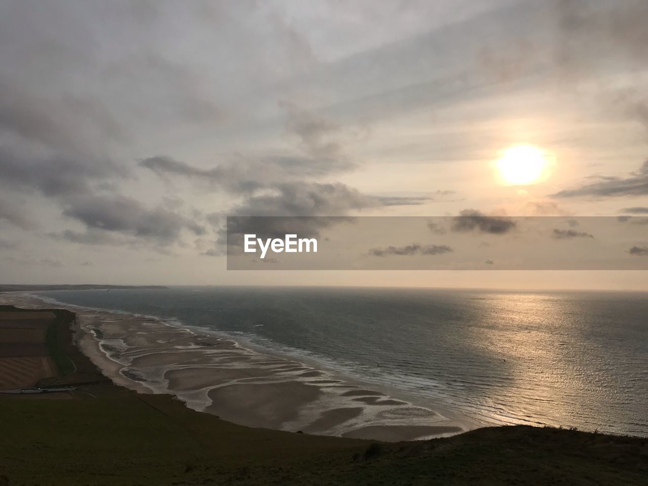 SCENIC VIEW OF BEACH AGAINST SKY AT SUNSET