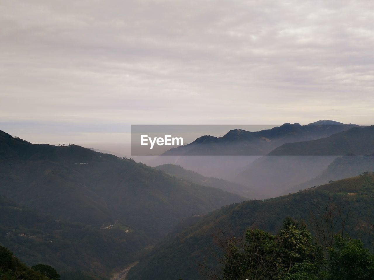 Scenic view of mountains against cloudy sky