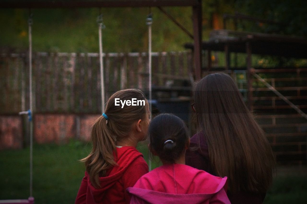 Rear view of girls at back yard