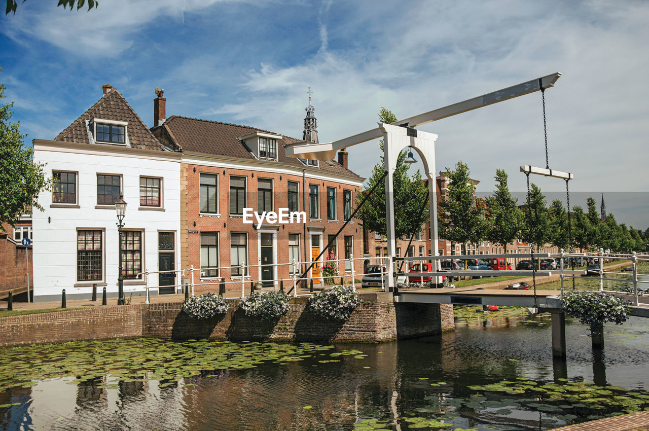 Canal with brick houses and bascule bridge in weesp. a pleasant small village in netherlands.