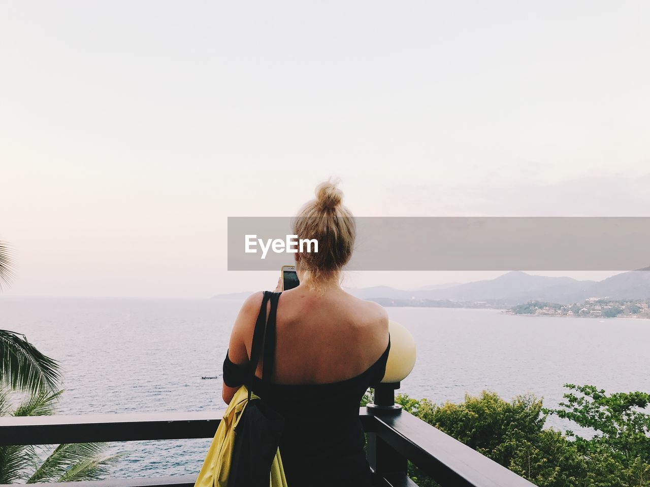 Rear view of woman looking at sea against sky