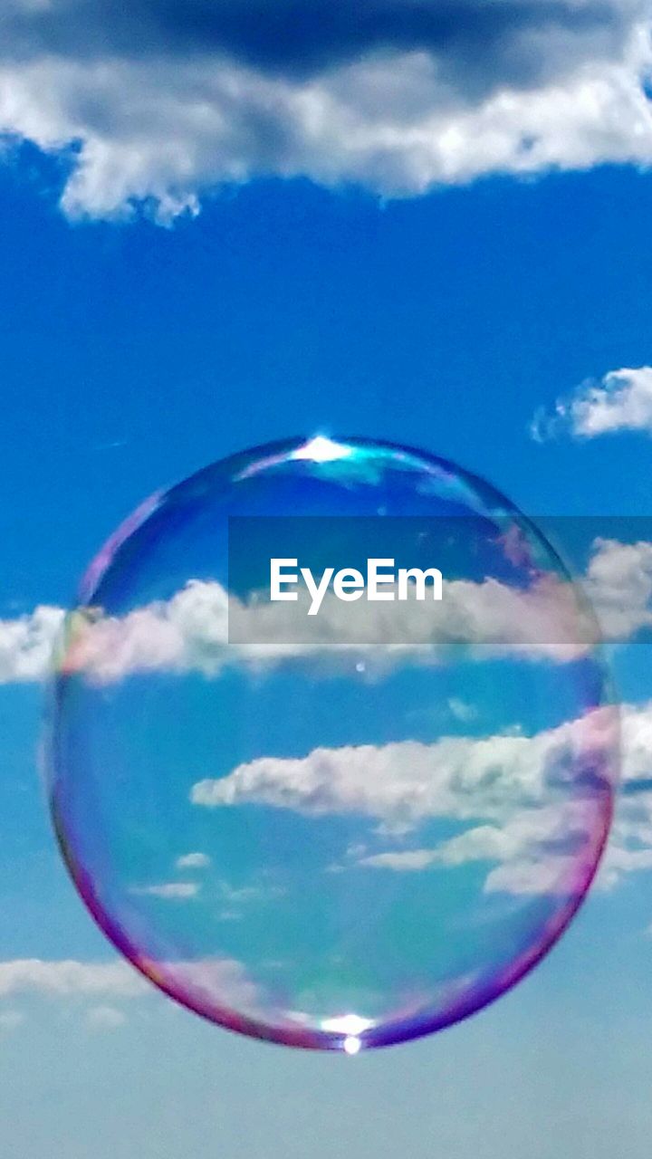 Close-up of bubble against blue sky