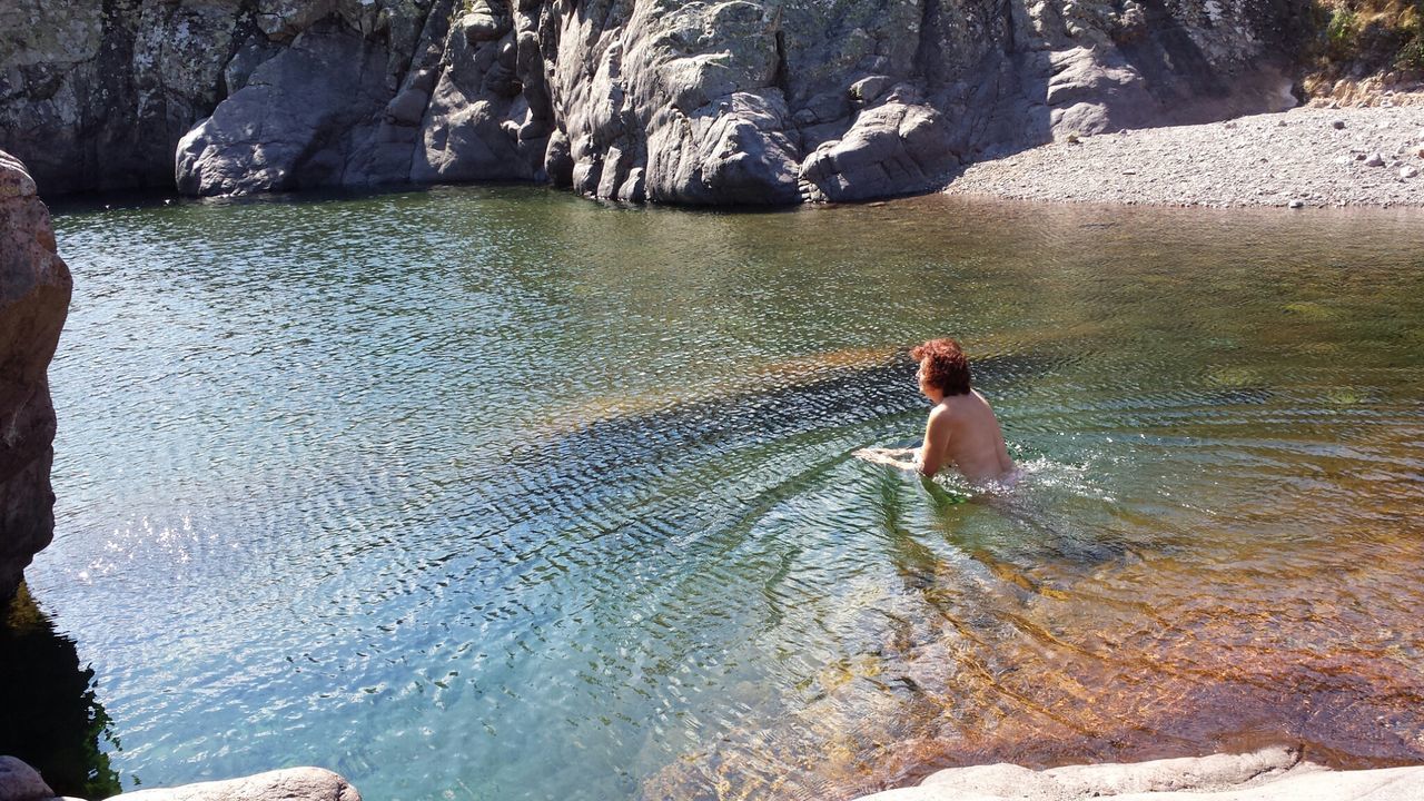 Topless woman swimming in lake