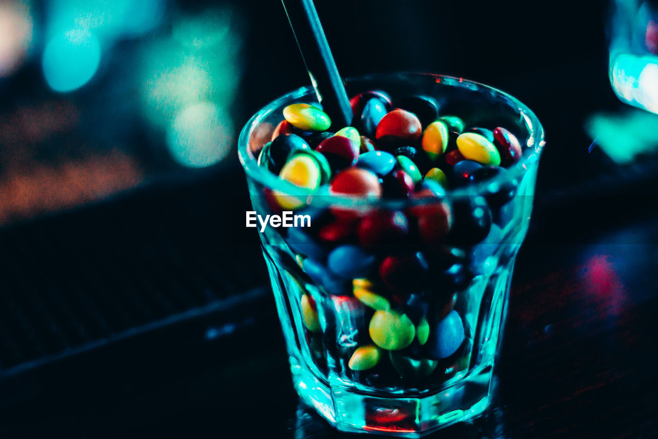 Close-up of colorful candies in drinking glass on table