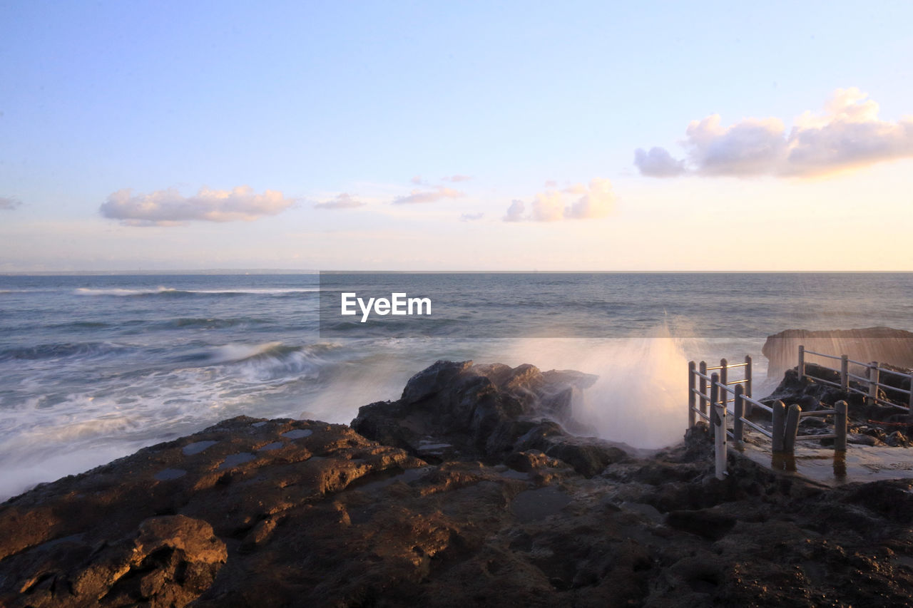 sea, sky, water, beach, horizon, ocean, land, shore, sunrise, beauty in nature, wave, coast, body of water, scenics - nature, horizon over water, nature, morning, rock, motion, cloud, dawn, tranquility, no people, travel destinations, seascape, wind wave, tranquil scene, outdoors, cliff, environment, sand, water sports, coastline, terrain, idyllic, bay, travel, sports, landscape