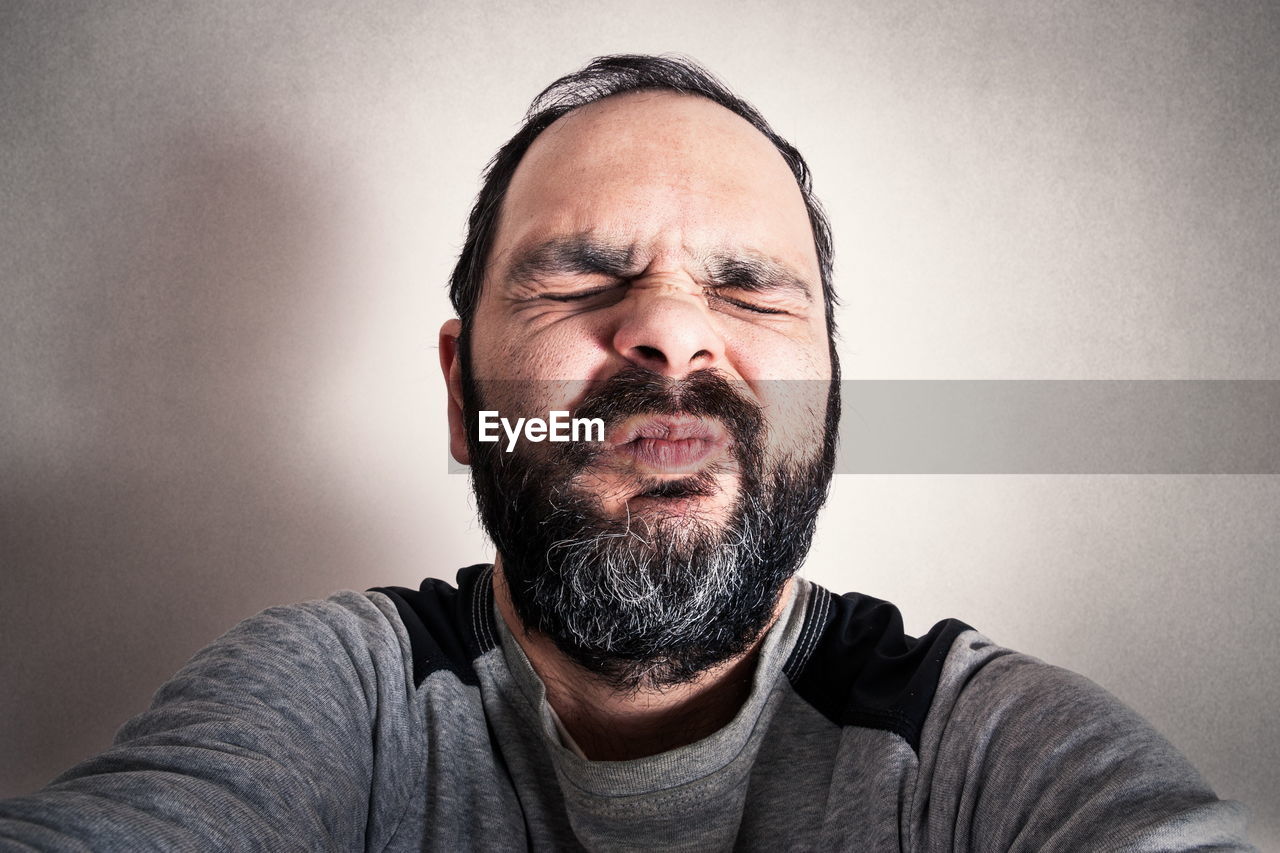 PORTRAIT OF MAN WEARING MASK AGAINST WALL