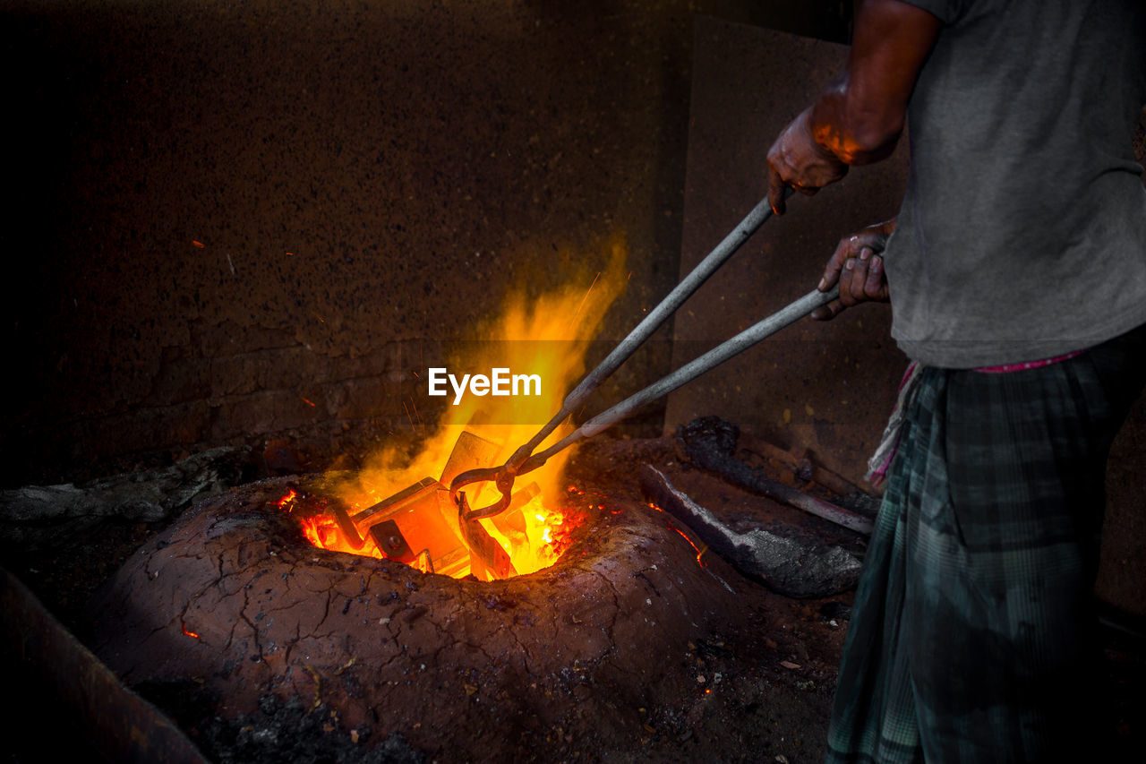 LOW ANGLE VIEW OF MAN WORKING ON FIRE