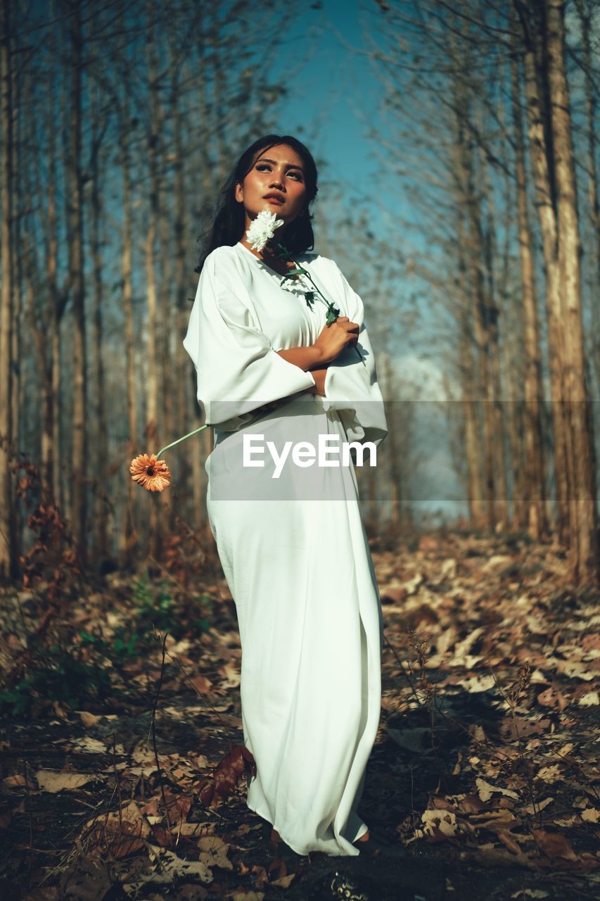 Full length of woman standing in forest