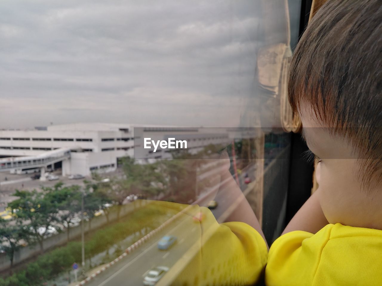 Side view of boy looking through window