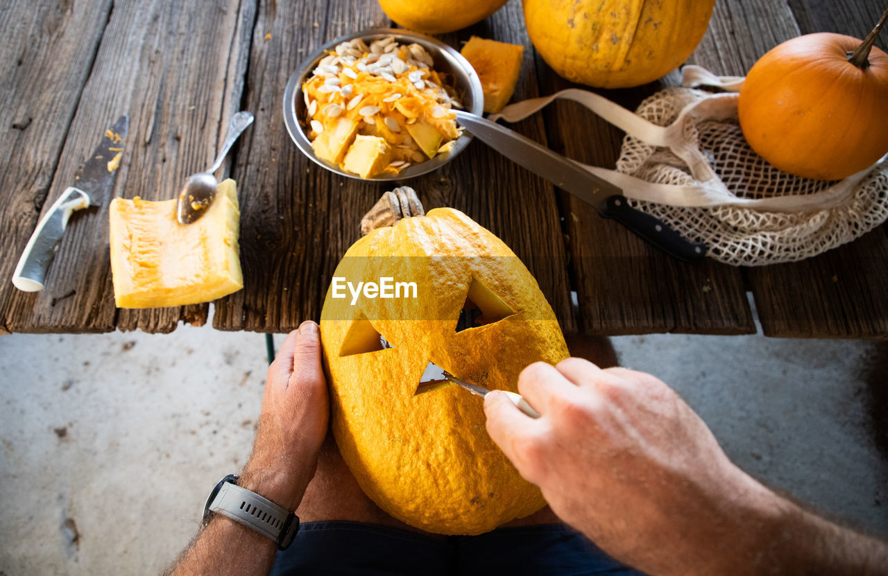 cropped hand of person with pumpkin