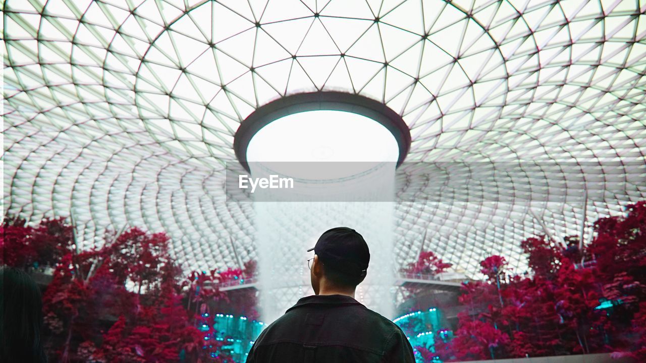 Rear view of man against modern fountain