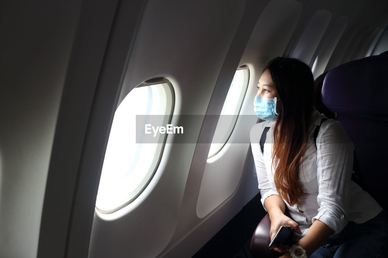 WOMAN SITTING BY AIRPLANE WINDOW