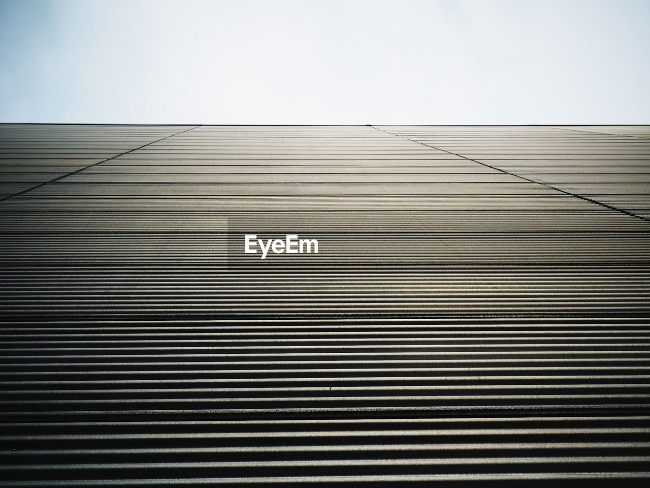 LOW ANGLE VIEW OF METALLIC BUILDING AGAINST SKY