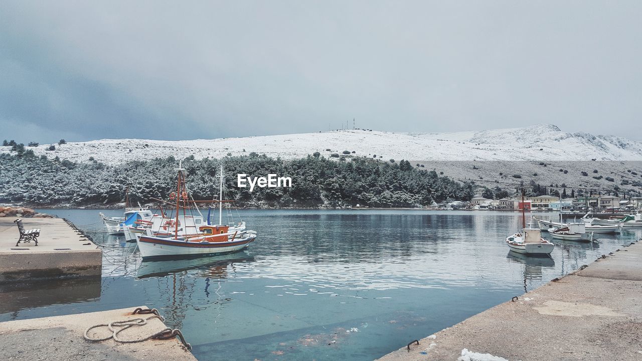BOAT MOORED ON SEA AGAINST SKY