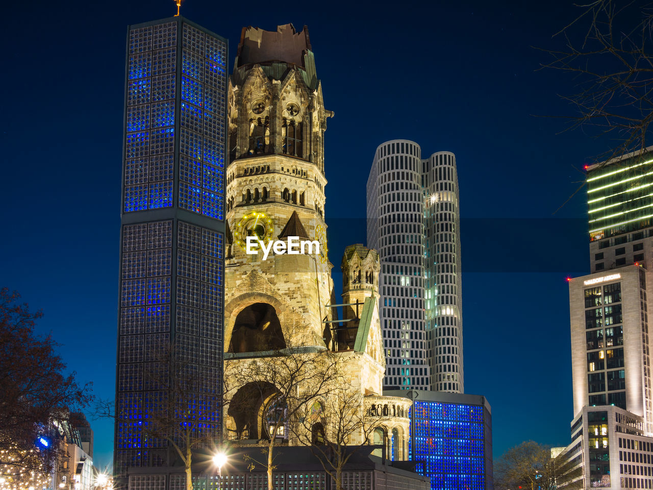 LOW ANGLE VIEW OF ILLUMINATED BUILDINGS AGAINST CLEAR BLUE SKY