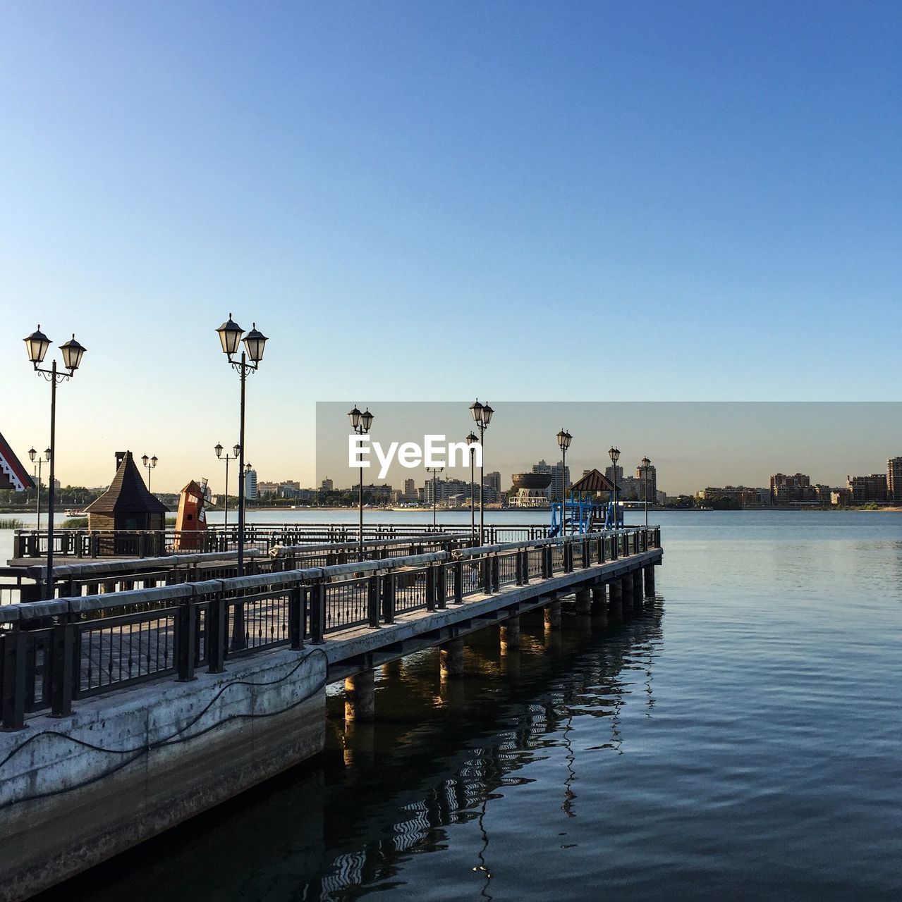 PIER ON RIVER AGAINST CLEAR BLUE SKY