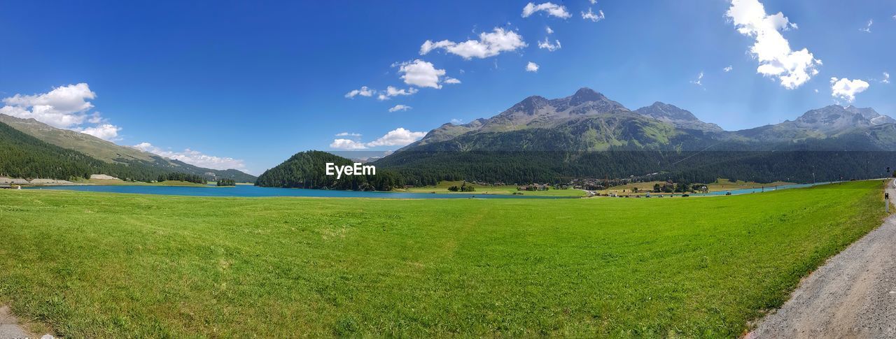 Panoramic view of field and mountains against sky