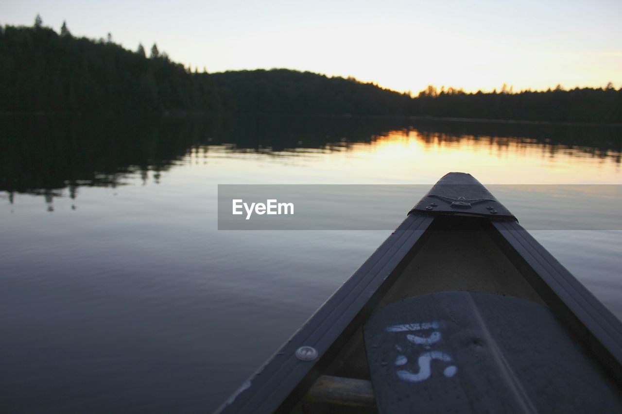 Cropped image of boat on calm lake against sky