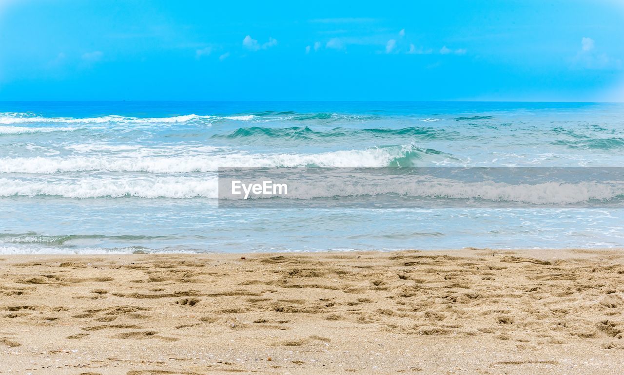 Scenic view of beach against blue sky