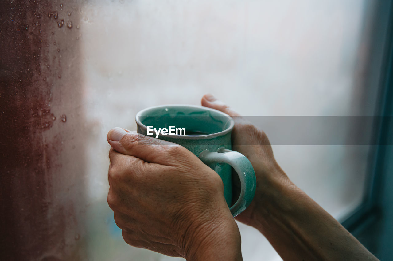 WOMAN HOLDING COFFEE CUP