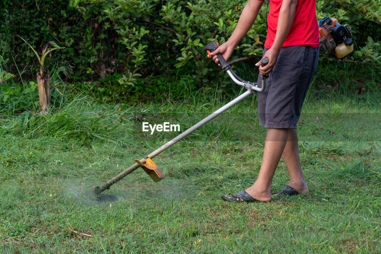 Low section of man mowing in yard